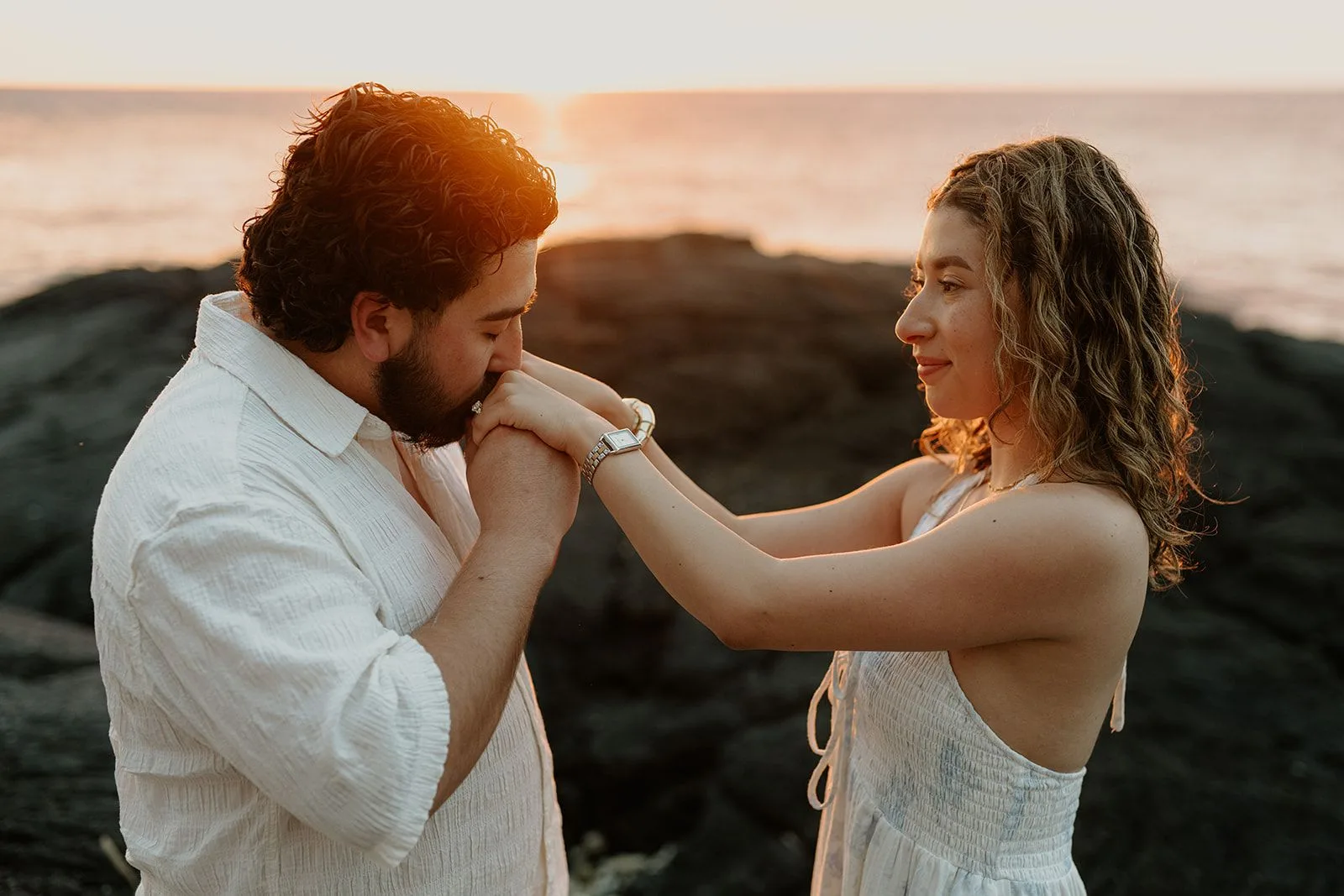 A couple sharing a quiet, golden-hour moment beside the ocean
